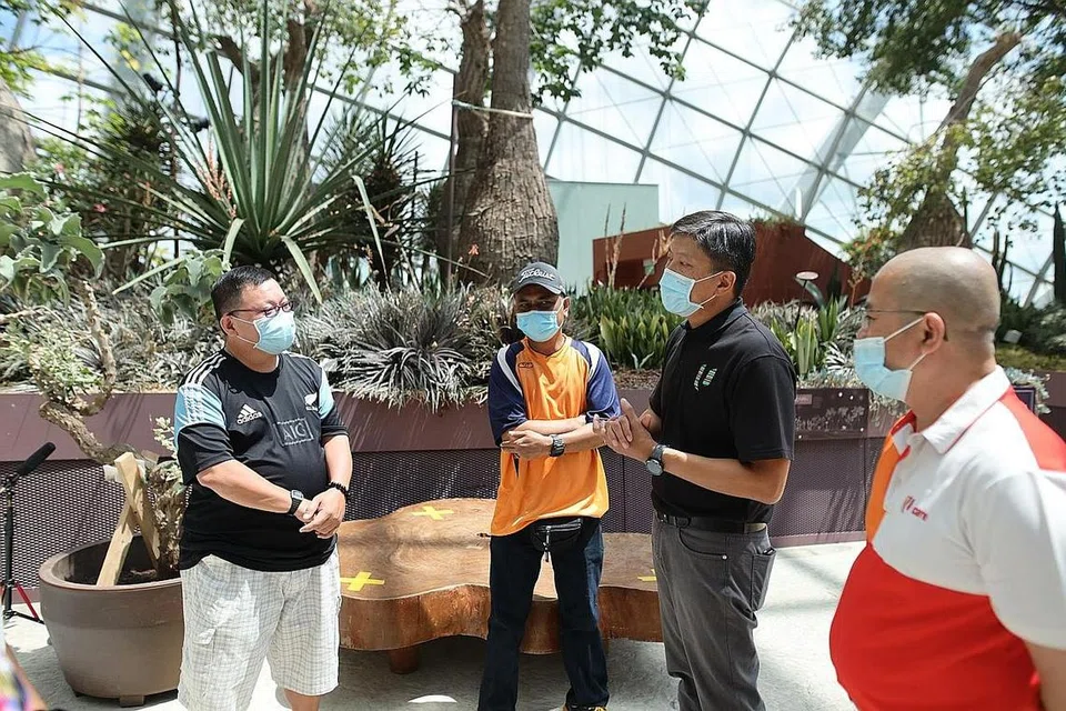 BANTUAN BAGI PEKERJA: Setiausaha Agung NTUC Ng Chee Meng (dua dari kanan) dan Penolong Setiausaha Agung NTUC Zainal Sapari (kanan) bertemu beberapa benefisiari Dana Penjagaan NTUC (Covid-19) di Gardens by the Bay pada November 2020. - Foto NTUC