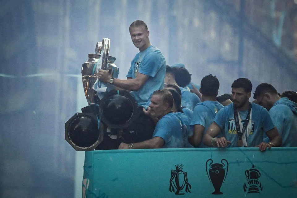 TERLALU GIRANG: Pemain Manchester City dari Norway, Erling Haaland, mengangkat trofi Liga Juara-Juara Eropah semasa berpesta dengan rakan sepasukan di bas yang membawa mereka berarak di kota Manchester.