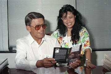 WARISAN BUDAYA MELAYU: Gambar yang dirakam pada 19 Ogos 1991 ini menunjukkan Allahyarham Othman Wok menyelak-nyelak halaman bukunya, Malayan Horror, bersama anaknya, Cik Lily Othman. Koleksi cerita seram Allahyarham ditulis semasa beliau menjadi wartawan pada 1950-an. Cik Lily menghimpun karya bapanya pada 1988 selepas kawannya memberitahunya beliau suka membacanya semasa kecil. - Foto fail BH