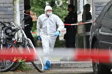 LAKUKAN SIASATAN: Seorang pegawai forensik bersama beberapa anggota polis dilihat di sekitar bangunan apartmen tempat kejadian pembunuhan itu berlaku di bandar Solingen, Jerman. - Foto EPA-EFE