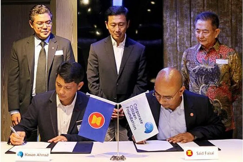 DETIK BERSEJARAH: Encik Hassan (duduk, kiri) dan pengarah eksekutif AHA Centre, Encik Said Faisal (duduk, kanan) menandatangani MOI antara CCF dan AHA Centre, sambil disaksikan (berdiri, dari kiri) Timbalan Setiausaha Agung Asean, Encik Vongthep Arthakaivalvatee; Menteri Pendidikan dan Menteri Negara Kanan (Pertahanan) Ong Ye Kung; dan pengerusi CCF, Encik Lim Choo Leng; di sambutan ulang tahun pertama CCF November lalu. - Foto AHA Centre