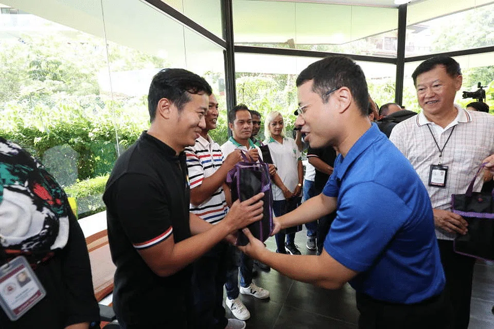 Encik Lee (kanan, baju biru) di satu lawatan ke Kemudahan Kuarantin Pemerintah di Civil Service Club di Loyang pada Ahad (29 Mac).