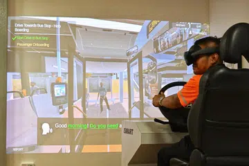 Demonstrasi latihan menggunakan simulator realiti campuran dilengkapi konsol pemanduan fizikal lengkap dengan brek dan set kepala realiti campuran.