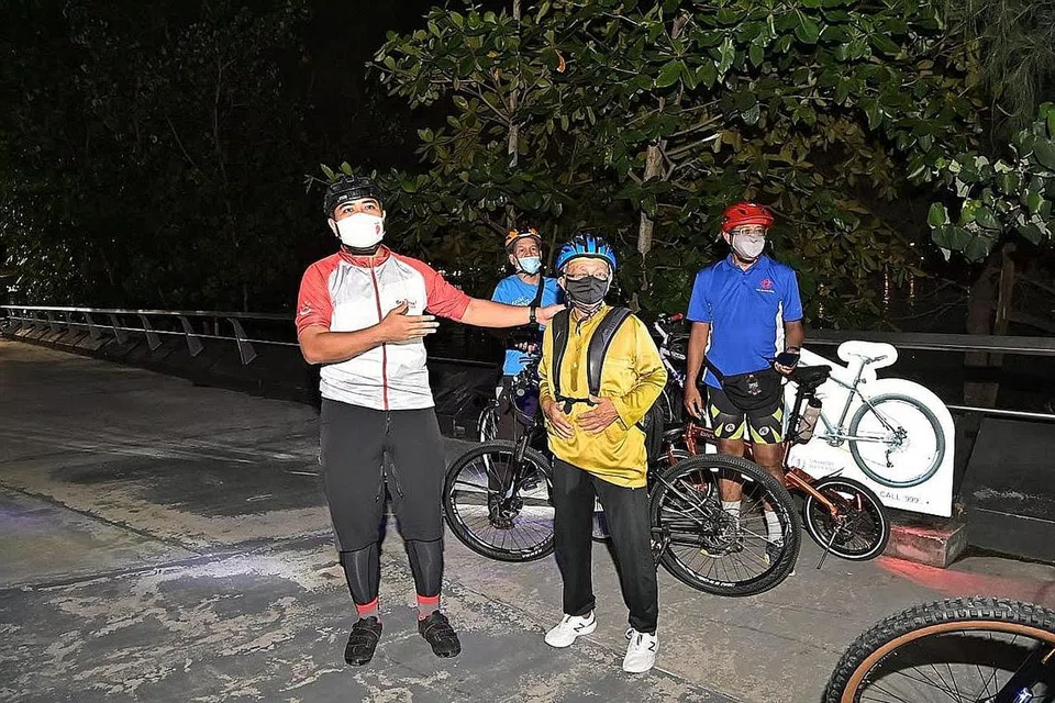 KAYUH TERUS: Setelah solat isyak dan tarawih, Encik Mohamed Yusoff terus turun trek Ramadan Ridedengan memakai baju Melayu. Sebelum acara bermula, Encik Sharael Taha (atas) dan Encik Mohamed Yusoff memberi kata-kata perangsang kepada peserta. - Foto-foto FACEBOOK SHARAEL TAHA