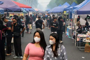 Wanita memakai pelitup muka ketika berjalan di sebuah pasar di Palangka Raya, Kalimantan Tengah, yang diselubungi jerebu akibat kebakaran hutan dan tanah semasa Hari Tanpa Kenderaan pada 6 September 2026. Jerebu berpanjangan di Kalimantan menjejas kesihatan dan kehidupan harian penduduk, dengan paras zarah halus berbahaya dilaporkan jauh melebihi tahap selamat yang disarankan Pertubuhan Kesihatan Sedunia (WHO).
