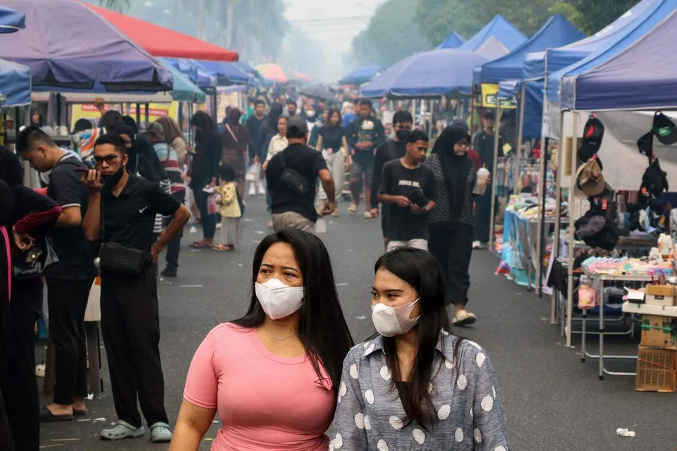 Wanita memakai pelitup muka ketika berjalan di sebuah pasar di Palangka Raya, Kalimantan Tengah, yang diselubungi jerebu akibat kebakaran hutan dan tanah semasa Hari Tanpa Kenderaan pada 6 September 2026. Jerebu berpanjangan di Kalimantan menjejas kesihatan dan kehidupan harian penduduk, dengan paras zarah halus berbahaya dilaporkan jauh melebihi tahap selamat yang disarankan Pertubuhan Kesihatan Sedunia (WHO).