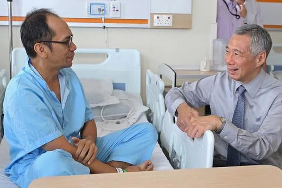 TEMUI PESAKIT: Encik Lee menemui pesakit, Encik Rais Misran, semasa mengunjungi Hospital Besar Ng Teng Fong (NTFGH) yang dibuka secara rasmi semalam. - Foto THE STRAITS TIMES