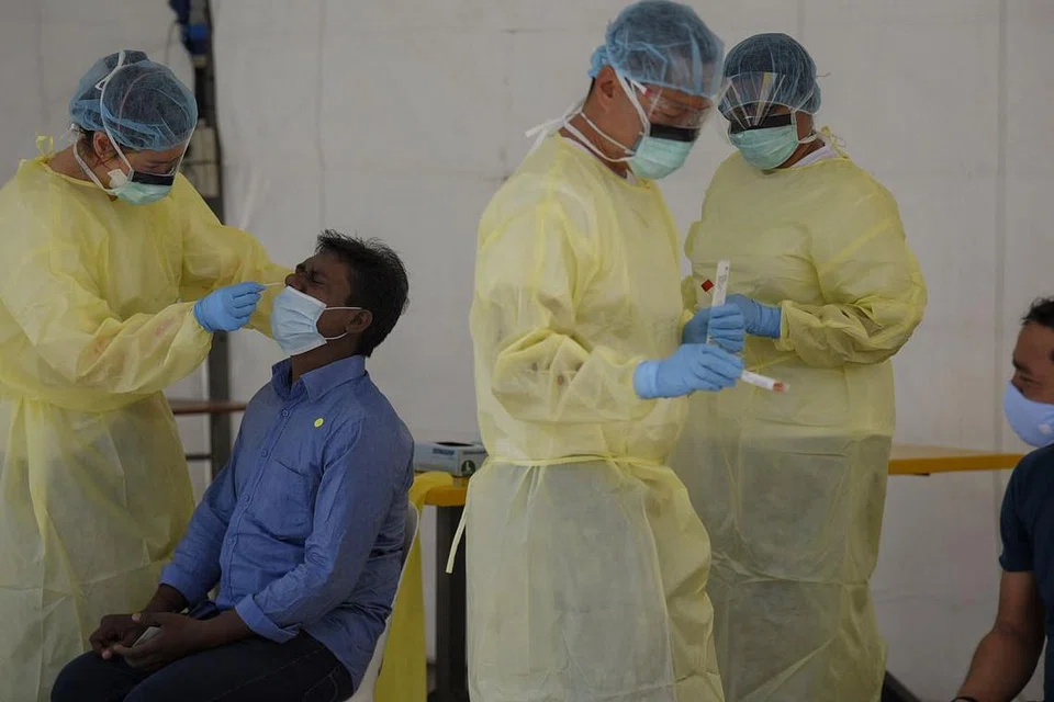 PEMERIKSAAN DIPERTINGKAT: Seorang pekerja asing dilihat sedang menjalani ujian swab Covid-19 di Dormitori Westlite Papan pada 21 April 2020. - FOTO: MARK CHEONG