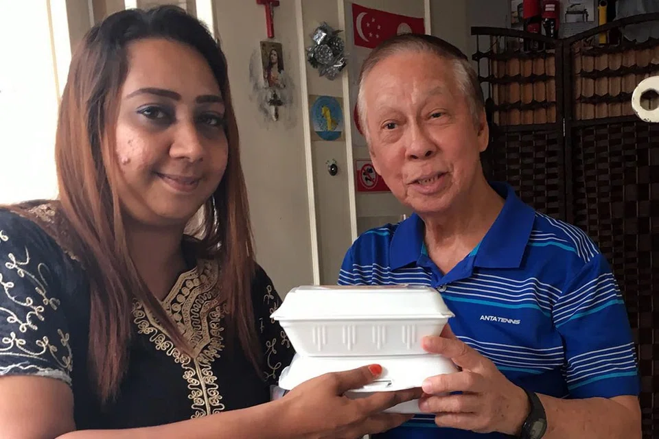 LEGA: Encik Choa Hin Loke, cef pesara, gembira dapat makanan percuma daripada sukarelawan FFA, Cik Zeenat Beve. - Foto DEWANI ABBAS 