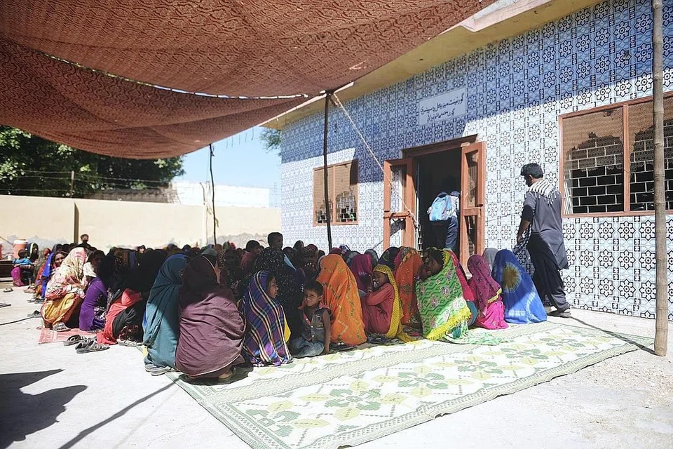 BERATUR PANJANG: Ratusan wanita duduk di luar sebuah bangunan pemberian ubat kampung yang diguna sebagai pusat rawatan percuma bagi ibu baru dan akan bersalin di kampung Mohammad Hashim Noodan, daerah Tando Allahyar, wilayah Sindh, Pakistan. 