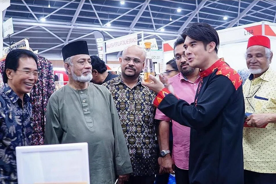 MAJLIS PEMBUKAAN PAMERAN: (Dari Kiri) Pengarah Urusan MegaXpress International, Encik Hamzah Abdullah; Presiden Persatuan Muhammadiyah, Ustaz Shaik Hussain Shaik Yacob; Lembaga Eksekutif Dewan Perniagaan Melayu Malaysia (DPMM) yang juga Naib Yang Dipertua DPMM Johor, Encik Muhammed Farhan Basheer, mendengar taklimat peniaga dari sebuah reruai mengenai produk yang dijual dalam pameran Halal Antarabangsa. - Foto BH oleh NUR DIYANA TAHA