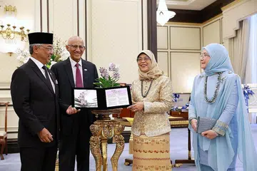 ORKID PENGHORMATAN: (Dari kiri) Yang di-Pertuan Agong Sultan Abdullah Ahmad Shah, Encik Mohamed Abdullah Alhabshee, Presiden Halimah Yacob dan Raja Permaisuri Agong Tunku Azizah Aminah Iskandariah di upacara menamakan orkid Vanda Halimah Yacob Mohamed. - Foto-foto ST