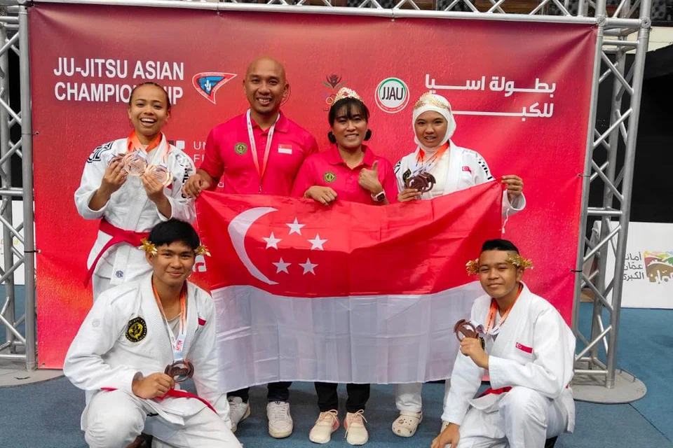 Pasukan jujitsu Singapura berjaya membawa pulang 11 pingat di Kejohanan Ju-Jitsu Asia 2025 di Amman, Jordan yang berlangsung dari 21 Mei hingga 27 Mei. Pengurus Prestasi Tinggi Atlet, Uli Fadhli (tiga dari kiri) dan Jurulatih Kebangsaan, Nordianawati Mohd Sadali (tiga dari kanan) berkata bahawa prestasi atlet mereka, termasuk (dari kiri) Aqil Zubair Taufek, Atiq Shazwani Roslan, Nayli Nur Syazleen Sazali dan Muhammad Farrel Danish Mohamed Farid, serta atlet lain melambangkan perpaduan, ketabahan dan kebanggaan yang kuat dalam kalangan mereka.