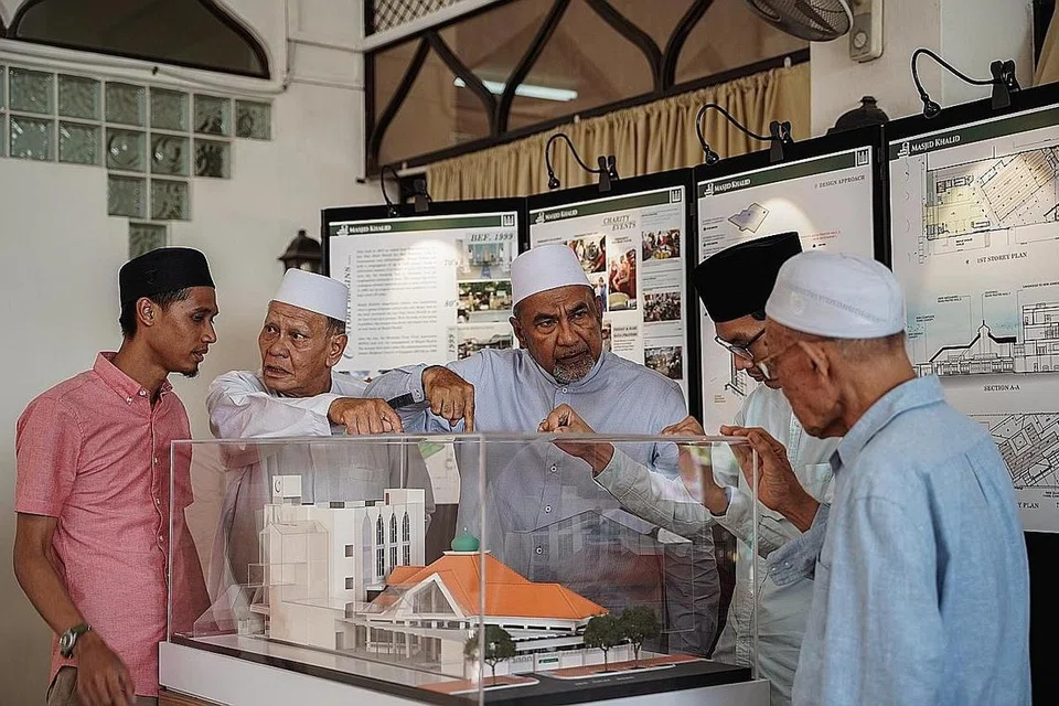 BILA SIAP KELAK: Dalam gambar yang diambil pada 2019 ini, Encik Allaudin (tengah) berbincang dengan beberapa kakitangannya mengenai bangunan baru masjid itu yang bakal menggantikan bangunan lama. - Foto 