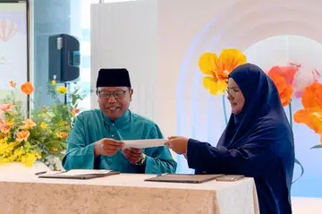 Pengerusi Eksekutif Masjid Ar-Raudhah, Encik Zuraimi Abdul Basheer dan Pengarah Travelwave, Cik Masmunah Abdullah melaksanakan majlis menandatangani sijil komitmen untuk pengumpulan dana menerusi projek “Umrah Beribadah Sambil Beramal” pada 26 September di Mamanda yang terletak di Boon Lay Way.