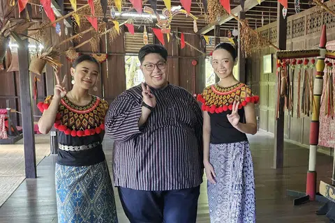 KENALI BUDAYA IBAN: Penulis (tengah) bersama para penari dari suku kaum Iban di dalam sebuah replika rumah panjang Iban. 