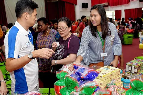 DAPAT BERJIMAT: Dengan adanya Projek 100=50, Cik Nor Raffidah (kiri) berkata keluarganya dapat membeli barangan keperluan harian pada harga lebih murah, sekali gus membolehkan mereka berjimat dan menggunakan wang itu untuk keperluan lain. - Foto BH oleh KHALID BABA