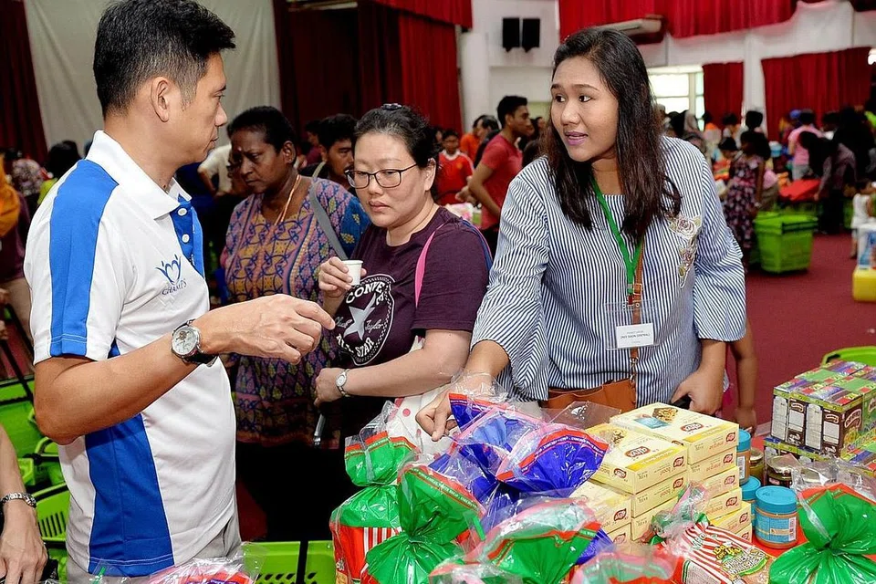 DAPAT BERJIMAT: Dengan adanya Projek 100=50, Cik Nor Raffidah (kiri) berkata keluarganya dapat membeli barangan keperluan harian pada harga lebih murah, sekali gus membolehkan mereka berjimat dan menggunakan wang itu untuk keperluan lain. - Foto BH oleh KHALID BABA