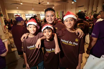 Penyelia operasi lapangan terbang UPS, Encik Mohamed Nazri Yusop (berdiri di belakang) bersama tiga anak lelakinya (dari kiri) Mohamed Irfan; Mohamed Luqman dan Mohamed Haikal di Pusat Penuaan Aktif Blossom Seeds pada 21 Disember.