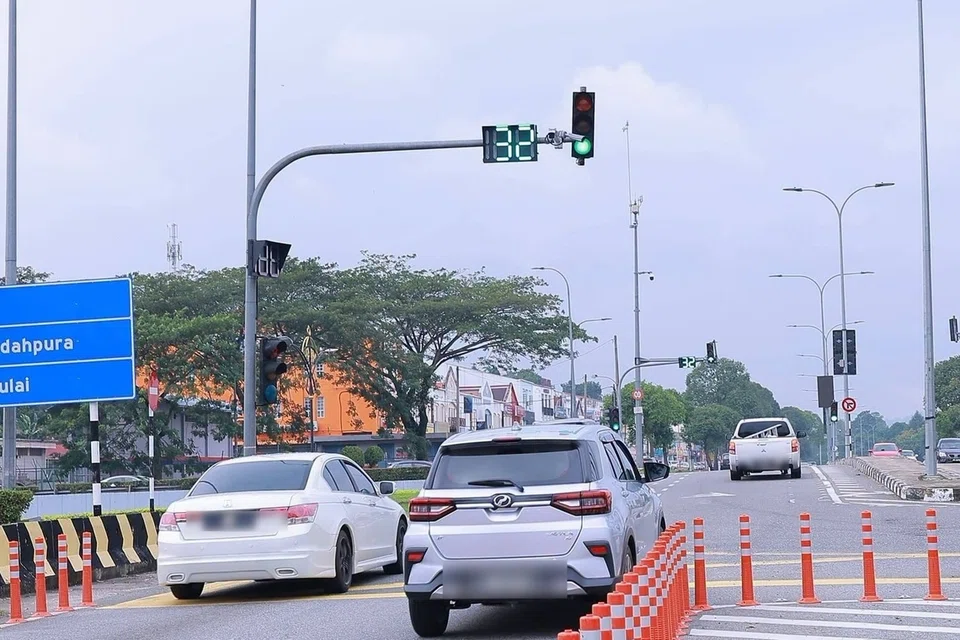 Sistem lampu isyarat pintar menggunakan sensor, kamera litar tertutup berasaskan kecerdasan buatan, pemasa dan alat kawalan untuk menyelaraskan tempoh lampu antara persimpangan berdasarkan jumlah kenderaan.