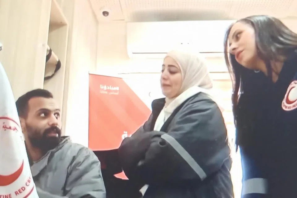 Seorang pegawai Bulan Sabit Merah Palestin mendengarkan rakaman audio perbualan dengan budak berusia enam tahun yang terperangkap dalam kereta bersama keluarganya yang sudah meninggal dunia.  