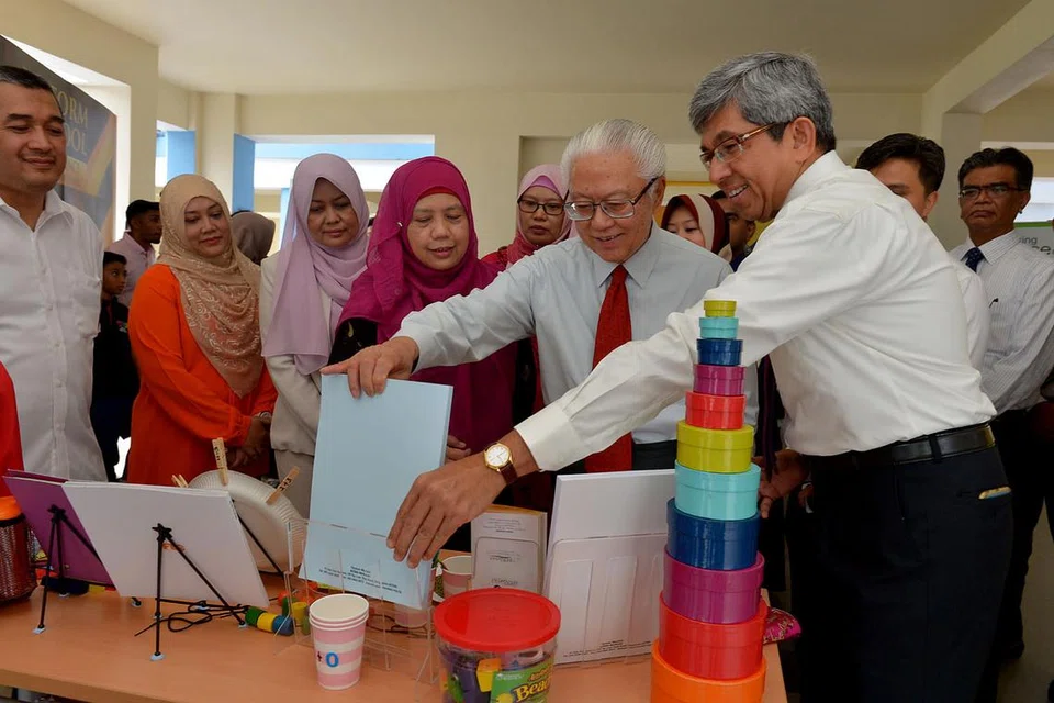 PELAWAT ISTIMEWA: Presiden Tony Tan (bertali leher merah) melawat pusat satelit Mendaki di Pasir Ris semalam diiringi Dr Yaacob (kanan) di mana beliau diberi taklimat mengenai program-program yang dijalankan Mendaki bagi masyarakat Melayu/Islam. - Foto TUKIMAN WARJI