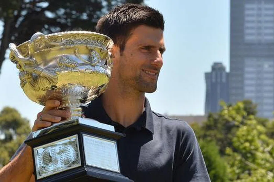 SANG JUARA DENGAN MAHKOTANYA: Novak Djokovic bergambar dengan trofi kejuaraan Terbuka Australia yang dimenanginya buat kali keenam kelmarin. - Foto AFP