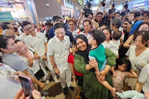 Penduduk Tampines berpusu-pusu untuk bergambar dengan Perdana Menteri, Encik Lawrence Wong (lima dari kiri) bersama pasukan Parti Tindakan Rakyat (PAP) GRC Tampines pada 30 April.