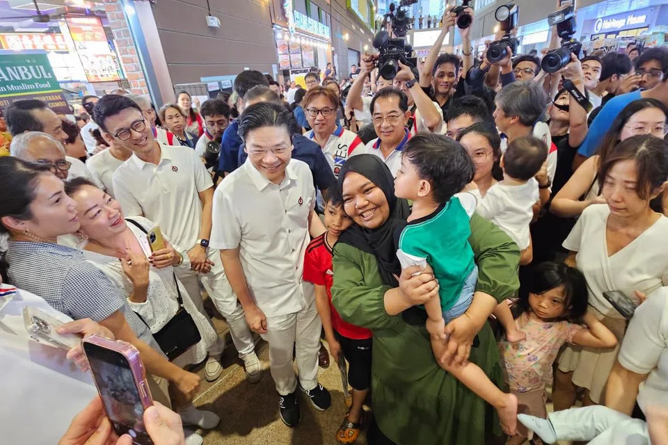 Penduduk Tampines berpusu-pusu untuk bergambar dengan Perdana Menteri, Encik Lawrence Wong (lima dari kiri) bersama pasukan Parti Tindakan Rakyat (PAP) GRC Tampines pada 30 April.