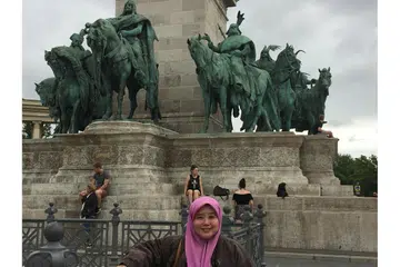 TEROKA SEJARAH SILAM SANG WIRA: Penulis menikmati angin petang dan pemandangan indah penuh bersejarah di Heroes Square, kompleks arca raksasa sekitar Andrassy Avenue bersebelahan taman awam City Park di Budapest, Hungary. Di belakang ialah arca tujuh ketua suku kaum Magyar (penduduk pertama Hungary). - Foto HARYANI ISMAIL
