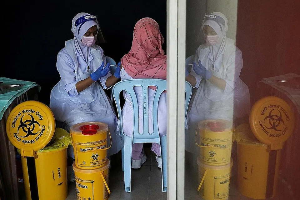 PERANGI COVID-19: Seorang jururawat memberi vaksin Covid-19 kepada pelajar di sebuah sekolah di Kuala Lumpur, sedang Malaysia meningkatkan program vaksinasinya. Peruntukan bajet bagi Kementerian Kesihatan adalah yang kedua terbesar selepas Kementerian Pendidikan. - Foto REUTERS