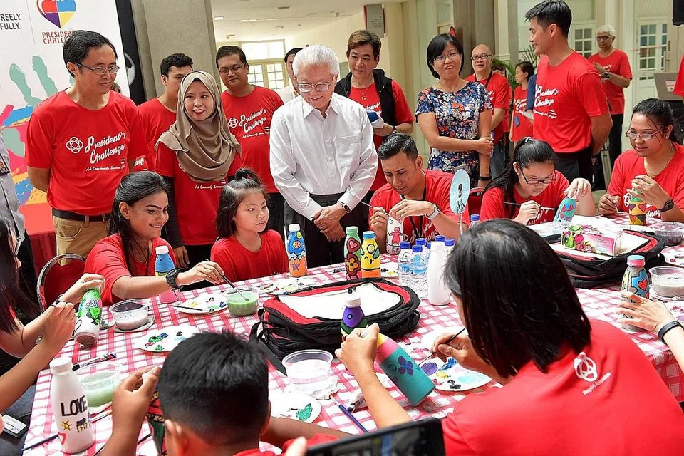 PROJEK MASYARAKAT: Presiden Tony Tan Keng Yam (berbaju putih) semasa menyaksikan bengkel melukis dan mereka botol dan beg yang diadakan ibu pejabat Persatuan Rakyat semalam. Produk yang dihasilkan akan digunakan untuk mengumpul dana. - Foto THE STRAITS TIMES