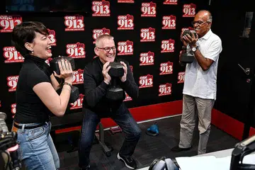 BERSENAM DI KONTI: (Dari kanan) Encik Shanmugam melakukan senaman angkat berat bersama deejay radio One FM 91.3, Mark van Cuylenburg, atau lebih dikenali sebagai Flying Dutchman, dan Angelique Teo, semasa di konti radio bagi 'The Big Show' pagi semalam. - Foto BH oleh KUA CHEE SIONG