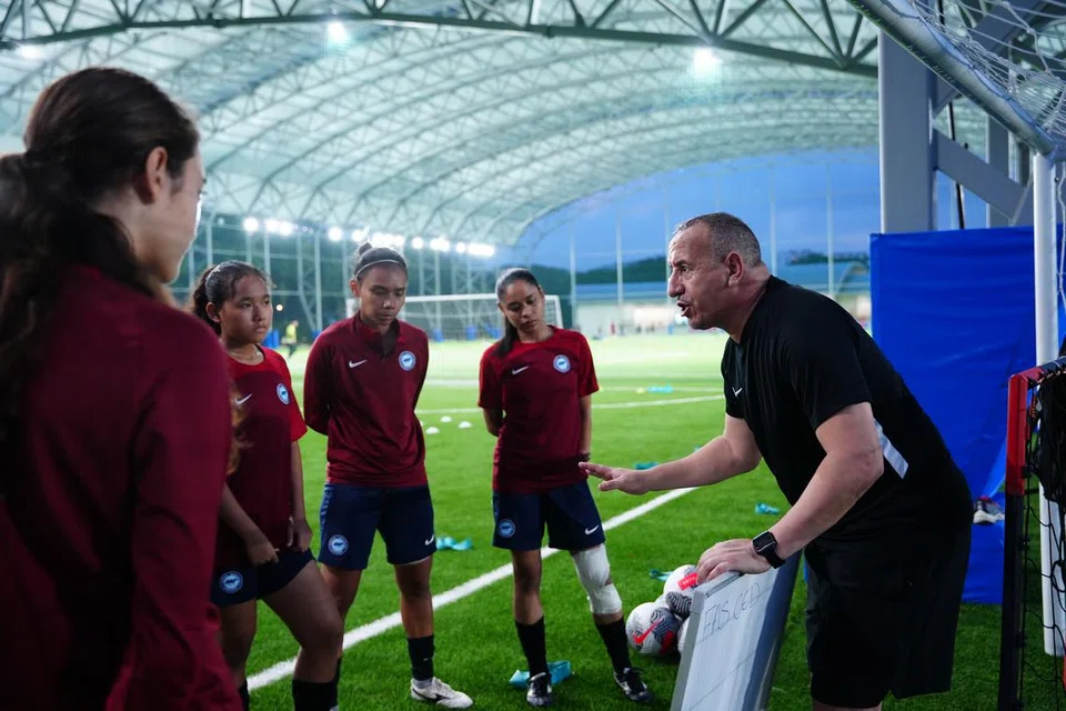 Ketua jurulatih pasukan nasional wanita Singapura, Karim Bencherifa (kanan), memberi arahan kepada pemain ketika satu sesi latihan di Hab Bola Sepak Kallang pada 12 Julai.