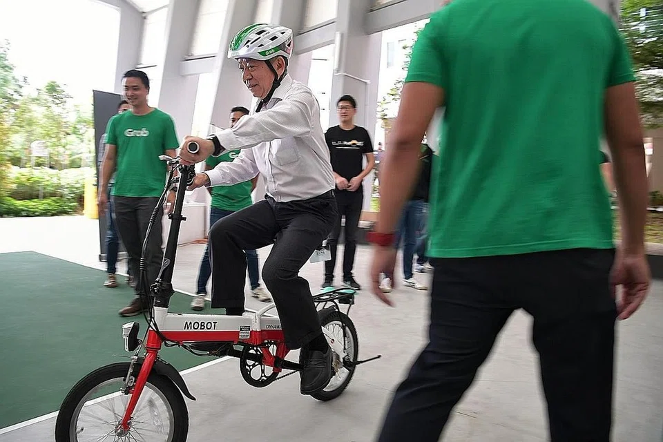 CUBA BASIKAL ELEKTRIK: Encik Khaw turut mengambil kesempatan mencuba basikal PAB ketika mengunjungi sesi latihan program 'Kit Penunggang Penghantaran' di Sin Ming Lane semalam. - Foto BH oleh KUA CHEE SIONG