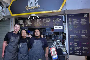 CEBURI BIDANG NIAGA: Encik Syafiq Lee (kiri) bersama dua pekerja beliau, Encik Muhd Haikal (tengah) dan Muhd Hidayat, di depan gerai beliau di Ashes Burnnit di Pusat Penjaja Golden Mile. - Foto BH oleh ZALEHA ABDUL KADER