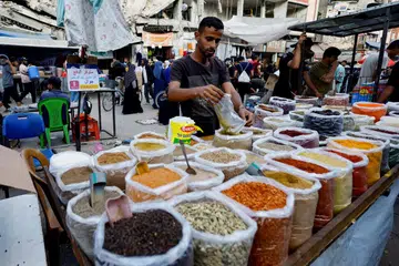 Penduduk Palestin membeli-belah di sebuah pasar di Nuseirat, tengah Jaluran Gaza, 28 Oktober 2025.