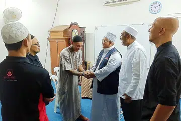 MENJADI TETAMU ALLAH: Ustaz Fadlon (tiga dari kanan) bersalaman dengan Encik Andyn, salah seorang daripada lapan bekas penagih dan pesalah dijadualkan mengerjakan umrah mulai semalam. Turut memberi mereka perangsang termasuklah Encik Alla'udin (dua dari kanan) dan Ustaz Basir (paling kanan). - Foto BH oleh SAINI SALLEH