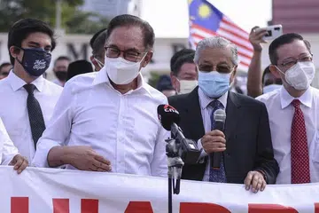 KEMBALI JALIN SINERGI: Bekas Perdana Menteri Malaysia, Mahathir Mohamad (kanan) dan ketua pembangkang, Anwar Ibrahim, ditemui media di perhimpunan protes penundaan sidang Parlimen pada Isnin (2 Ogos). - Foto AFP/ARIF KARTONO 