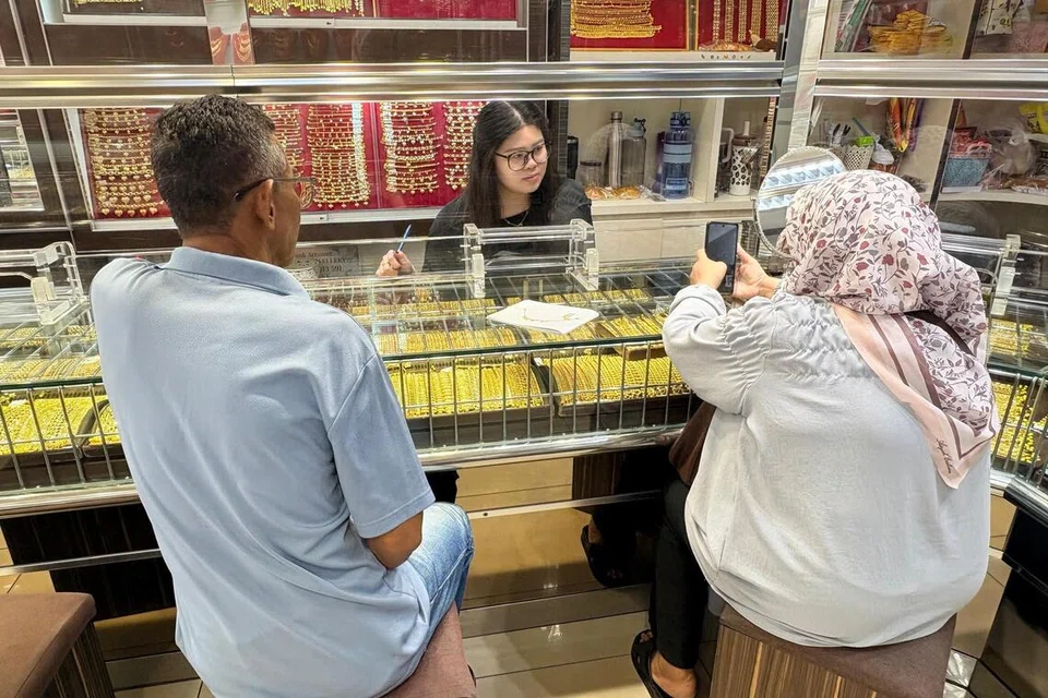 Cik Norsila Akim, 61 tahun (kanan), disantuni pengusaha Kedai Emas Jin Wei di Port Dickson, Negeri Sembilan, Cik Jeslyn Lim (tengah).