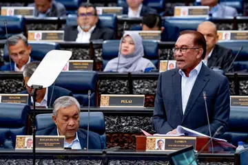 BERI PENJELASAN: Datuk Seri Anwar Ibrahim (berdiri) sedang menjelaskan tentang isu pembebasan kes rasuah melibatkan Datuk Dr Ahmad Zahid Hamidi (depan, kiri) apabila sejumlah anggota pembangkang keluar meninggalkan Dewan Parlimen. 
