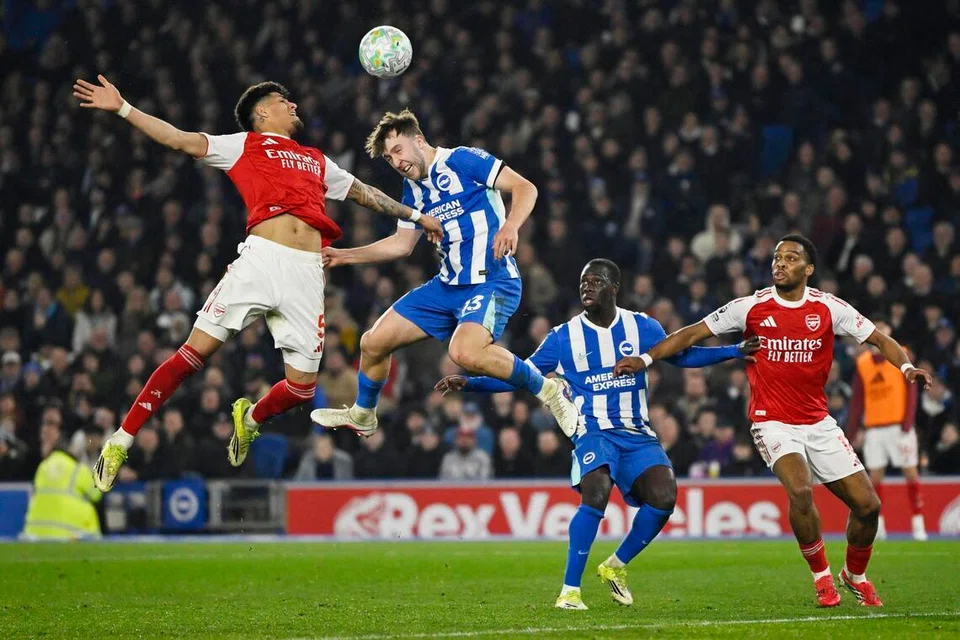 Pemain Arsenal, berebut bola dengan pemain Brighton Jack Hinshelwood. The Gunners mendahului takhta liga dengan kelebihan tujuh mata ke atas pencabar terdekat, Manchester City, yang seri 2-2 menentang Nottingham Forest tetapi kurang satu perlawanan berbanding Arsenal.