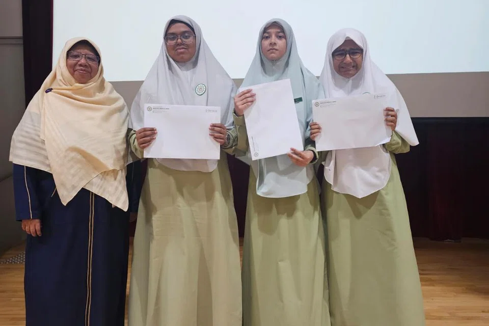 Mudirah Madrasah Al-Arabiah, Cik Aisha Abdul Manaf (kiri), bersama tiga pelajar cemerlang madrasah. Mereka terdiri daripada (dari dua dari kiri) Yusra Tasnim Habiba, Mohamed Malick Rafah Naz dan Kazi Laaibah Wania. 