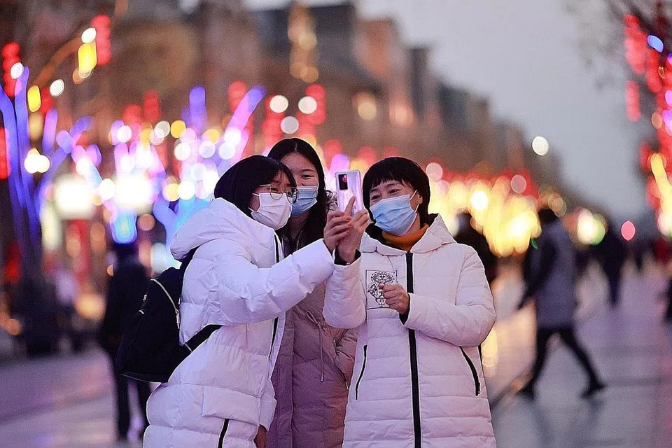 ANGKARA COVID-19: Orang ramai mengambil swafoto di jalan bersejarah di Beijing Isnin lalu yang dihiasi bagi menyambut perayaan tahun baru ekoran penularan wabak koronavirus. - Foto REUTERS