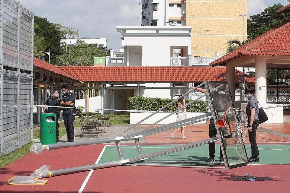 SIASATAN DIJALANKAN: Para penyiasat dan pegawai polis berada di tempat kejadian semalam setelah seorang remaja berusia 17 tahun meninggal dunia apabila struktur bola keranjang di Bedok menimpanya malam kelmarin. - Foto BH oleh TIMOTHY DAVID