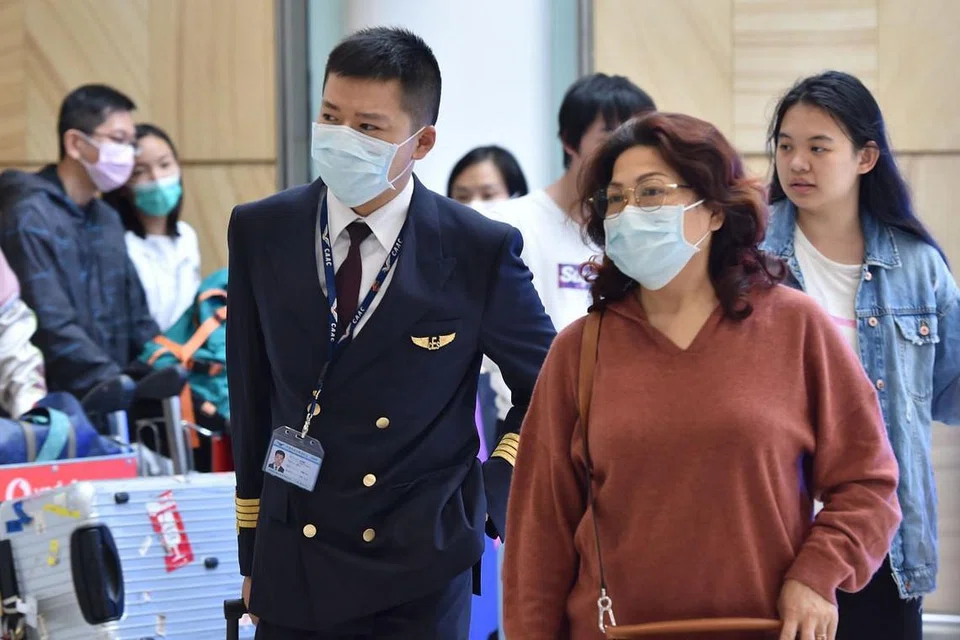 LANJUTKAN LARANGAN: Juruterbang China Eastern Airlines bersama penumpang pesawat kelihatan tiba di lapangan terbang Sydney dari China pada 25 Januari - Foto:AFP