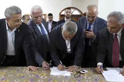 TANDATANGANI PERJANJIAN: Encik Ismail Haniyeh, Perdana Menteri Hamas (tengah), dan Encik Azzam al-Ahmad, ketua pemimpin kanan Fatah (kedua dari kiri), di upacara menandatangani perjanjian perpaduan antara kedua-dua pihak. - Foto REUTERS