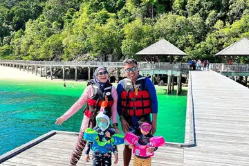 PERCUTIAN DI PULAU: Pasangan suami isteri, Cik Maria Baluyut dan Encik Nurul Azlan Md Rais, 36 tahun, bersama anak mereka, Emma Elisa Nurul Azlan (kanan), dan Matin Muttaqin Nurul Azlan, bersiap sedia untuk snorkeling di laut semasa percutian mereka di Pulau Tengah, Mersing, Malaysia. - Foto ihsan MARIA BALUYUT