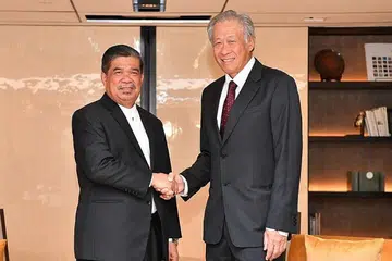 PERTEMUAN: Menteri Pertahanan, Dr Ng Eng Hen, dengan rakan sejawatannya dari Malaysia, Encik Mohamad Sabu, dalam mesyuarat rasmi pertama mereka, yang berlangsung di luar Dialog Shangri-La, pada 3 Jun 2018. - Foto MINDEF