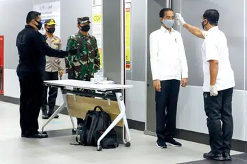 KEBIASAAN BARU: Presiden Indonesia, Encik Joko Widodo (dua dari kanan) memakai pelitup dan menjalani pemeriksaan suhu badan semasa mengunjungi sebuah stesen MRT di Jakarta semalam, bagi memeriksa langkah-langkah yang dilaksanakan bagi mengekang penularan koronavirus. 